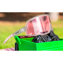 Óculos de sol transparente unissex com armação máscara e lente única rosa não refletiva, polarizada com proteção UV400. O acessório é leve, confortável e não escorrega ou pula no rosto ao realizar esportes.