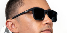Óculos de sol preto unissex com armação quadrada para rosto pequeno e lente preta não refletiva, polarizada com proteção UV400. O acessório é leve, confortável e não escorrega ou pula no rosto ao realizar esportes.