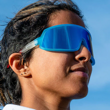 Óculos de sol azul-branco degradê unissex com armação máscara e lente única azul espelhada, polarizada com proteção UV400. O acessório é leve, confortável e não escorrega ou pula no rosto ao realizar esportes.
