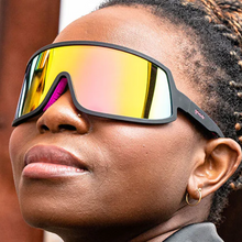 Óculos de sol preto unissex com armação máscara e lente única rosa espelhada, polarizada com proteção UV400. O acessório é leve, confortável e não escorrega ou pula no rosto ao realizar esportes.