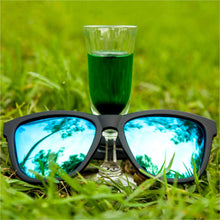 Óculos de sol preto unissex com armação quadrada e lente verde espelhada, polarizada com proteção UV400. O acessório é leve, confortável e não escorrega ou pula no rosto ao realizar esportes.