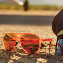 Óculos de sol vermelho unissex com armação aviador e lente rosa espelhada, polarizada com proteção UV400. O acessório é leve, confortável e não escorrega ou pula no rosto ao realizar esportes.