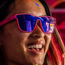 Óculos de sol rosa unissex com armação quadrada e lente única roxa espelhada, polarizada com proteção UV400. O acessório é leve, confortável e não escorrega ou pula no rosto ao realizar esportes.