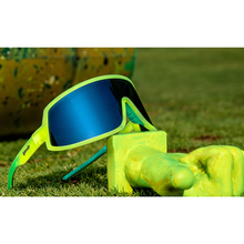 Óculos de sol verde unissex com armação máscara e lente única cinza espelhada, polarizada com proteção UV400. O acessório é leve, confortável e não escorrega ou pula no rosto ao realizar esportes.