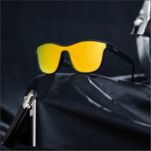 Óculos de sol preto unissex com armação quadrada e lente única amarela espelhada, polarizada com proteção UV400. O acessório é leve, confortável e não escorrega ou pula no rosto ao realizar esportes.