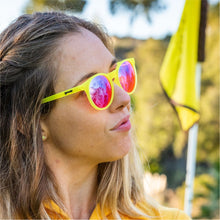 Óculos de sol amarelo unissex com armação redonda e lente rosa não refletiva, polarizada com proteção UV400. O acessório é leve, confortável e não escorrega ou pula no rosto ao realizar esportes.