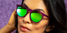 Óculos de sol roxo unissex com armação redonda e lente verde espelhada, polarizada com proteção UV400. O acessório é leve, confortável e não escorrega ou pula no rosto ao realizar esportes.