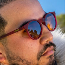 Óculos de sol bordô unissex com armação redonda e lente marrom não refletiva, polarizada com proteção UV400. O acessório é leve, confortável e não escorrega ou pula no rosto ao realizar esportes.