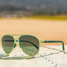 Óculos de sol verde unissex com armação aviador e lente verde não refletiva, polarizada com proteção UV400. O acessório é leve, confortável e não escorrega ou pula no rosto ao realizar esportes.