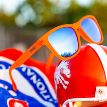Óculos de sol laranja unissex com armação quadrada e lente azul espelhada, polarizada com proteção UV400. O acessório é leve, confortável e não escorrega ou pula no rosto ao realizar esportes.